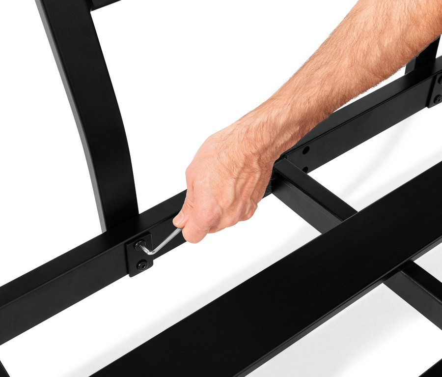 Mann zieht eine Schraube an einer flexiblen Lounge-Ecke mit Duraboard®-Tischplatten mit einem Inbusschlüssel fest.