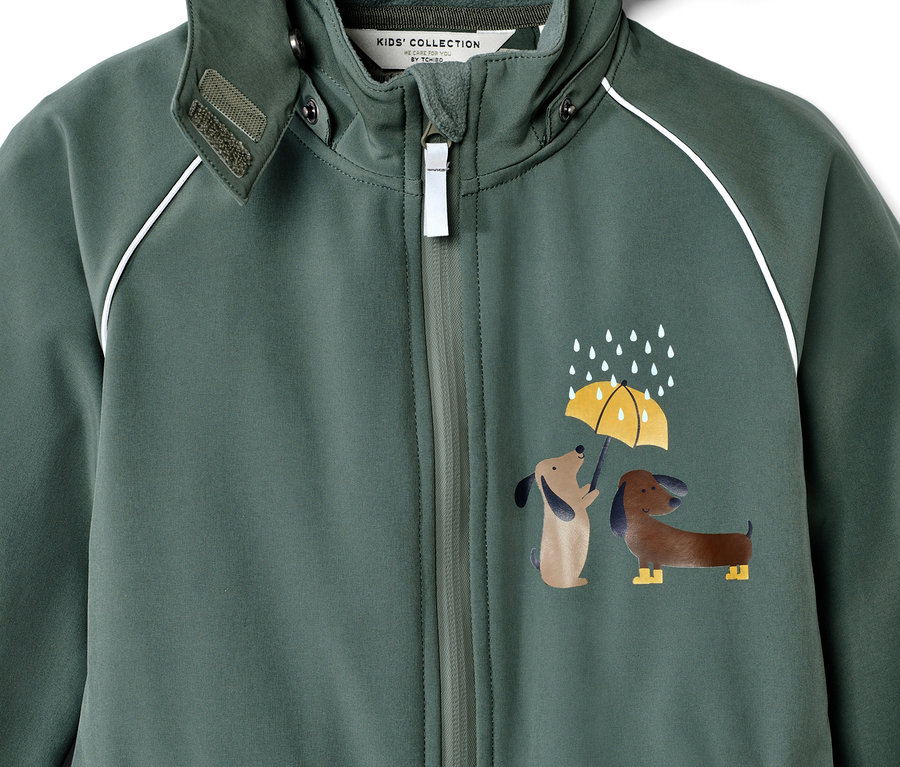 Detailansicht eines Kinder-Softshell-Einteilers mit Hunde- und Regenmuster.