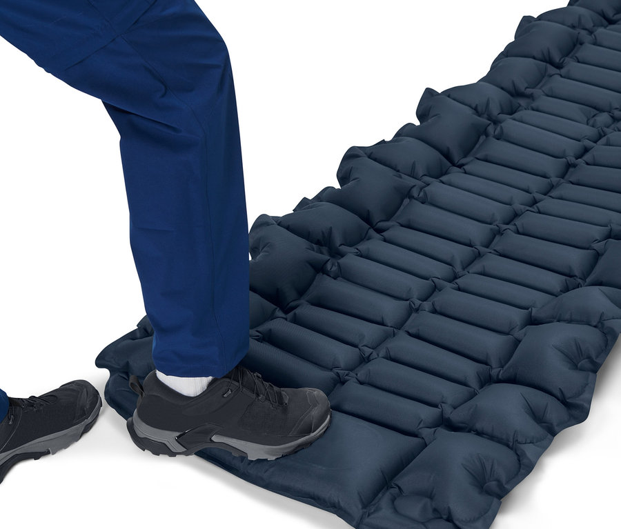 Eine Person steht auf einer Luftmatratze mit integrierter Fußpumpe.