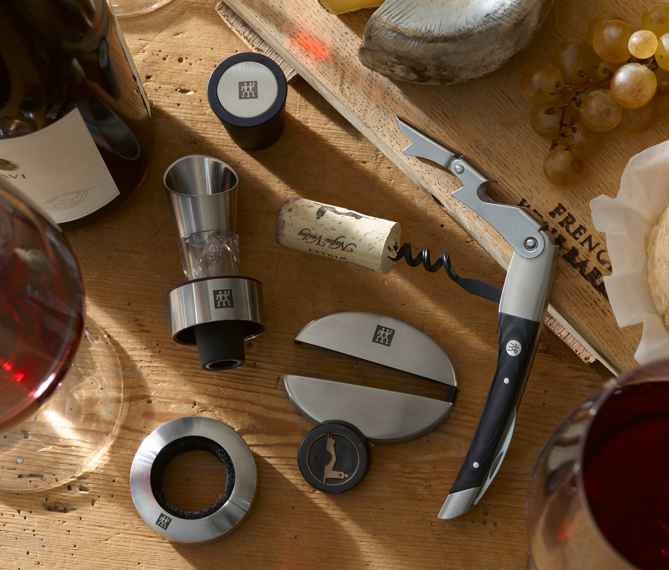 Wein, Käse und ein ZWILLING Sommelier-Set auf einem Holztisch.