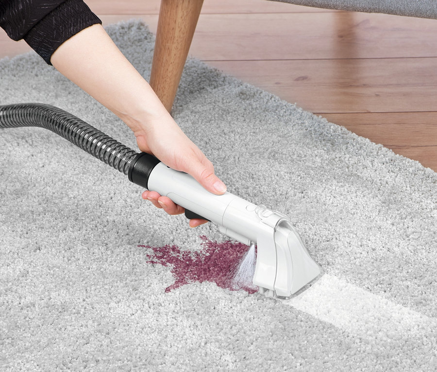 Frau reinigt grauen Teppich mit N8Werk Teppich-und-Polsterreiniger »3522«.