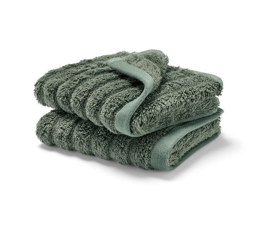 Zwei grüne Premium-Gästehandtücher gestapelt.
