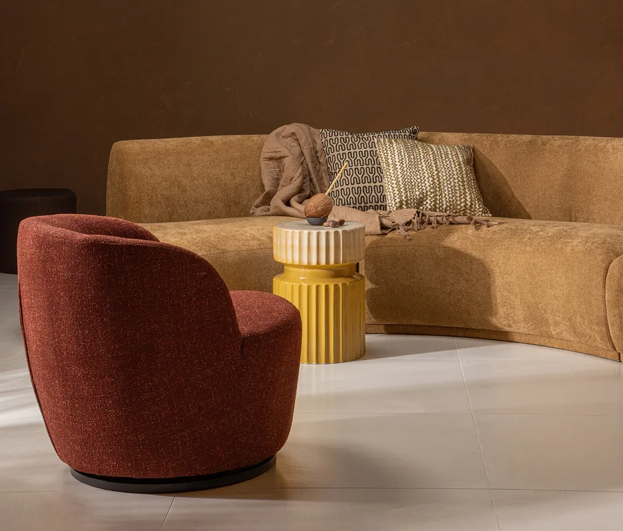 Ein brauner Sessel steht neben dem senffarbenen Woood Beistelltisch »Geer« und einem braunen Sofa.