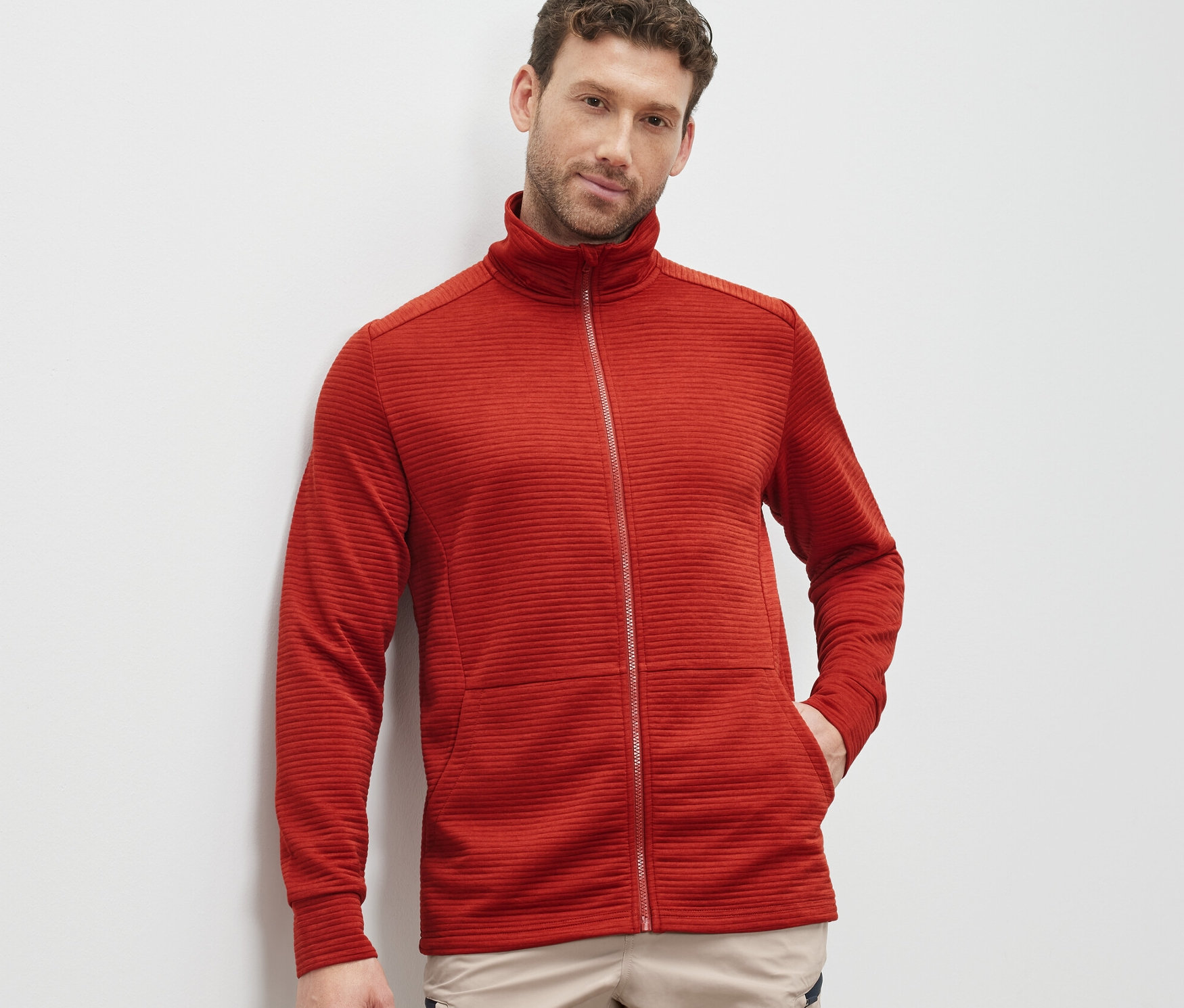 Mann trägt rote Funktionsjacke.