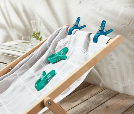 Auf einer Strandliege liegen 4 Handtuchclips.
