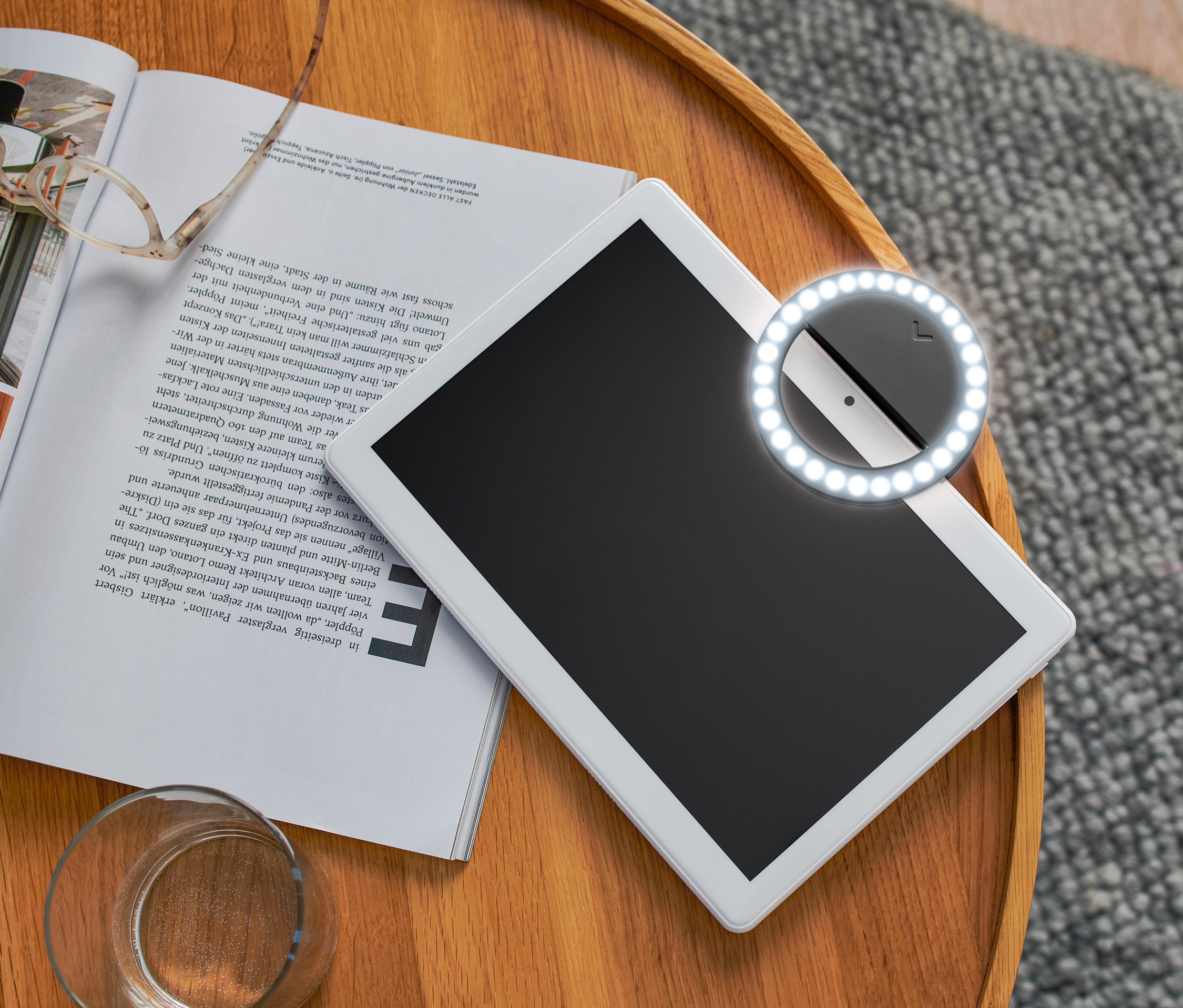 Tablet mit LED-Selfie-Lichtring mit 30 LEDs auf einem Holztisch neben einer Zeitschrift.