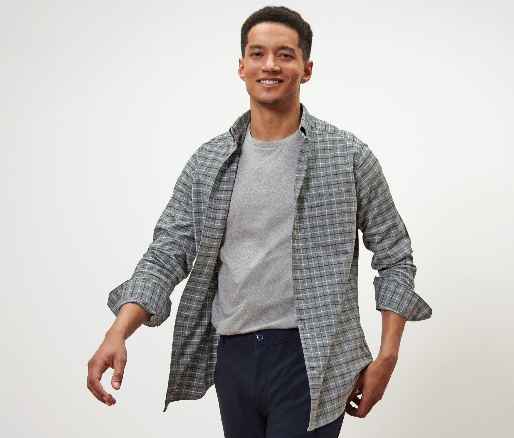 Mann trägt ein Flanell-Hemd und ein graues T-Shirt.