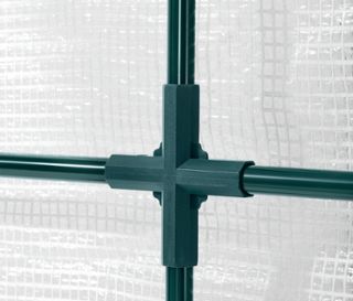 Detailansicht eines grünen Anlehn-Pflanzenschutz-Zelts mit weißem Netz im Hintergrund.