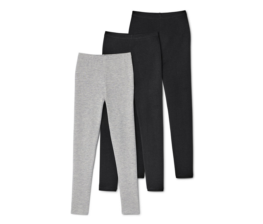 Drei Leggings in Grau und Schwarz liegen auf einem weißen Hintergrund.