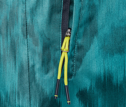 Nahaufnahme einer Regenhose mit Alloverprint und teilweise geöffnetem Reißverschluss.