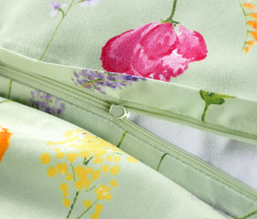 Nahaufnahme von geöffneter Microfaser-Bettwäsche in Normalgröße mit Blumenmuster.