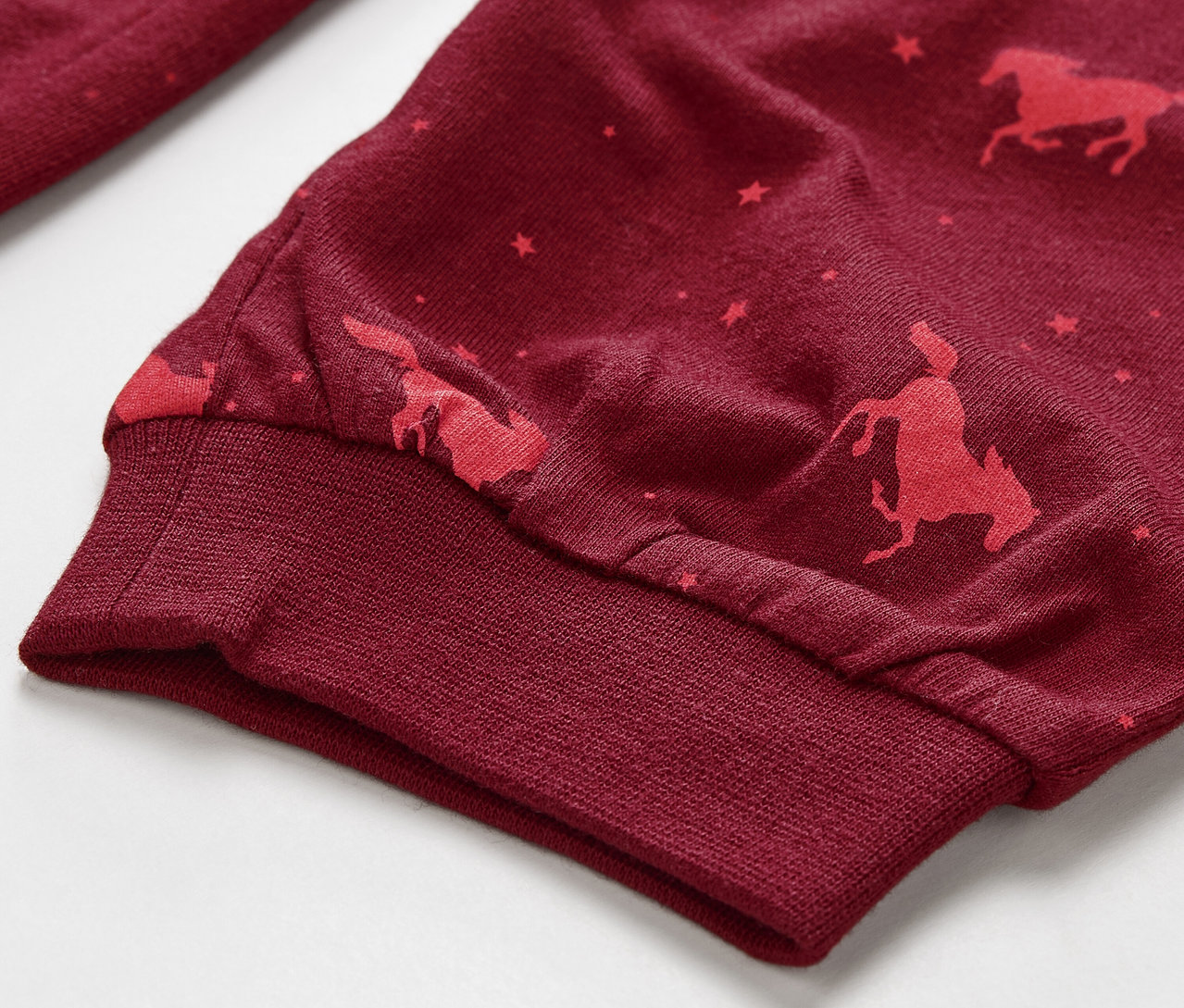 Detailaufnahme eines Kinderpyjamas mit Pferde-Print