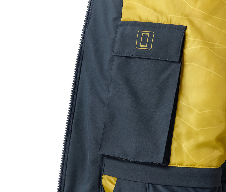 Detailansicht einer High-Tech-Skijacke mit Handytasche und gelbem Futter.