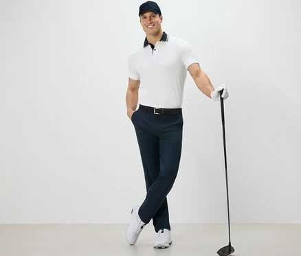 Mann posiert mit Golfschläger, trägt eine Outdoorhose.