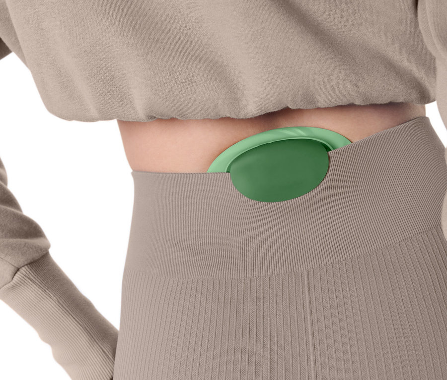 Eine Frau hat einen grünen Massageball in ihrer Hose.