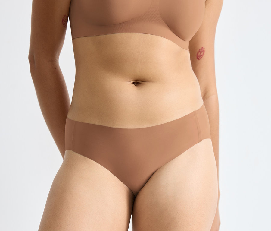 Frau trägt braunen BH und sloggi ZERO Feel 2.0 High leg Slip, nostalgic brown.