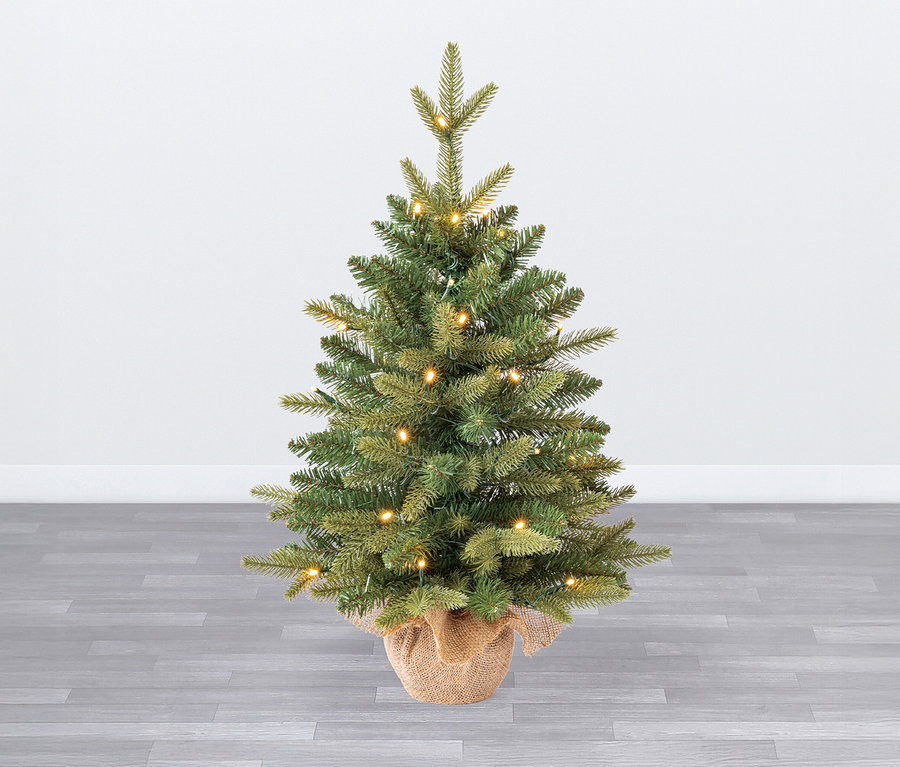 Ein 60 cm großer LED-Weihnachtsbaum »Aspen« mit Übertopf steht auf einem grauen Holzboden vor einer weißen Wand.