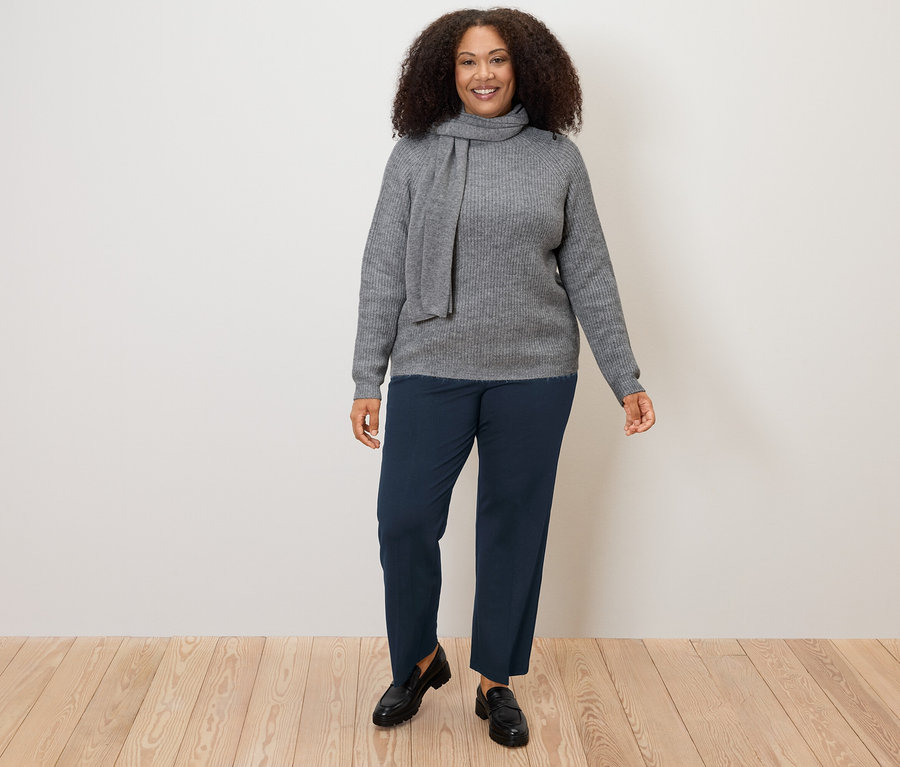 Frau trägt grauen Pullover und dunkelblaue Komfort-Jerseyhose.