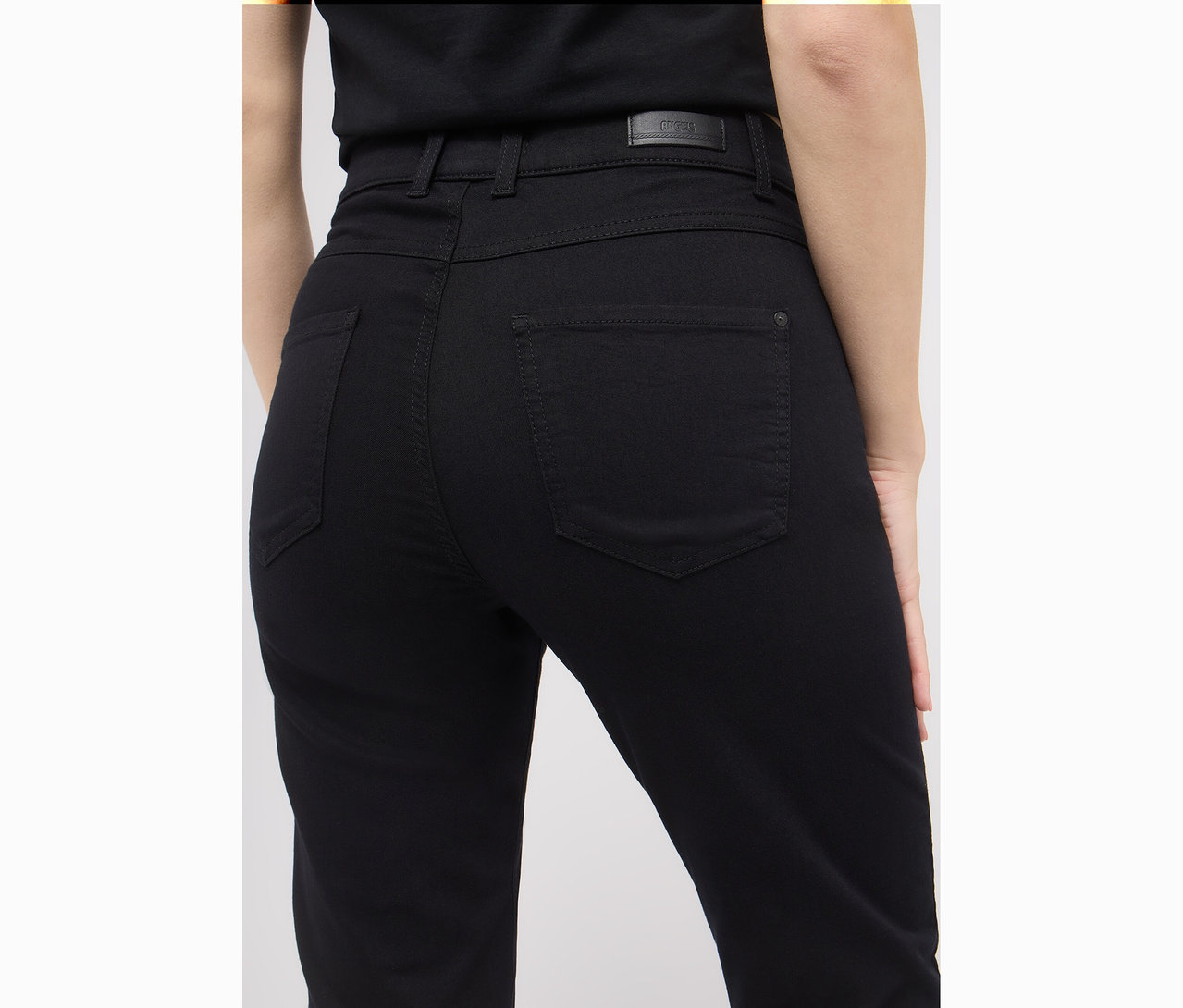 Nahaufnahme der Rückseite einer Frau, die schwarze Angels Denim »Lara« Straight Fit Jeans trägt.