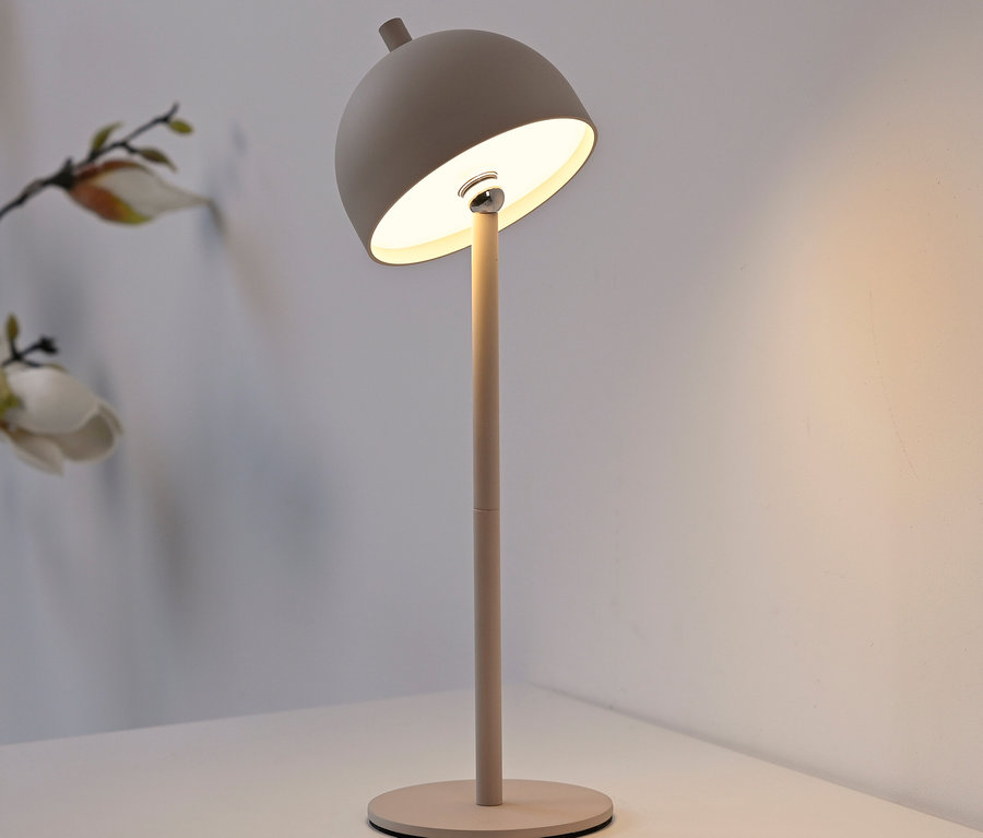 Eine graue Lampe steht auf einem Tisch.