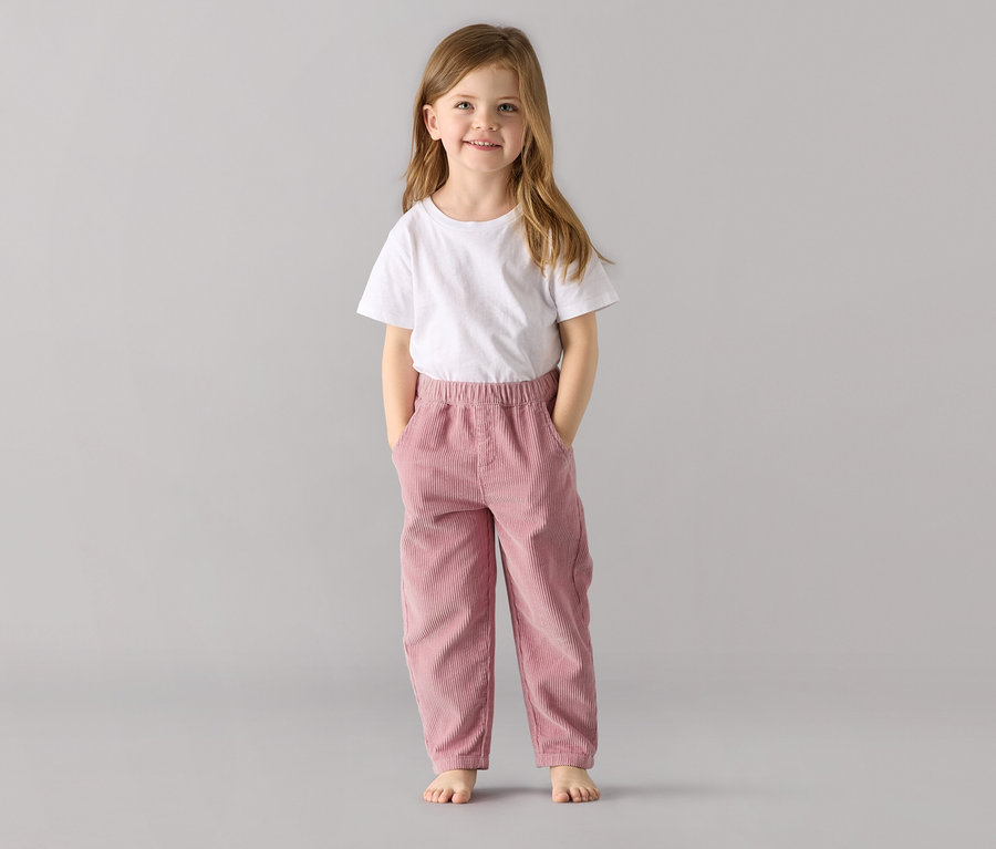 Mädchen steht in Kinder-Pull on pants – Fit »Mika«, altrosa und weißem T-Shirt.