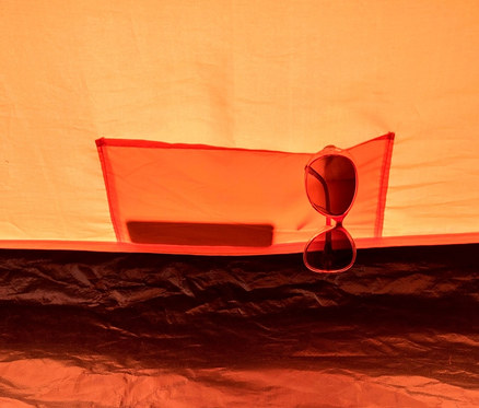 Sonnenbrille hängt an einer Tasche im Inneren eines orangefarbenen Tambu 2-Personen-Kuppelzelts »HAIKA 2».