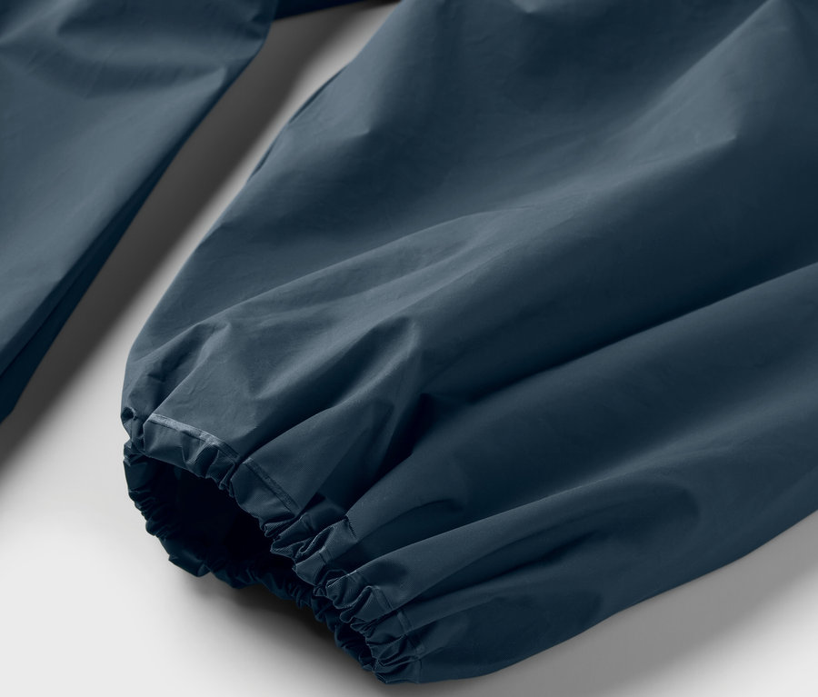 Detailaufnahme des Ärmels eines blauen Regenponchos.