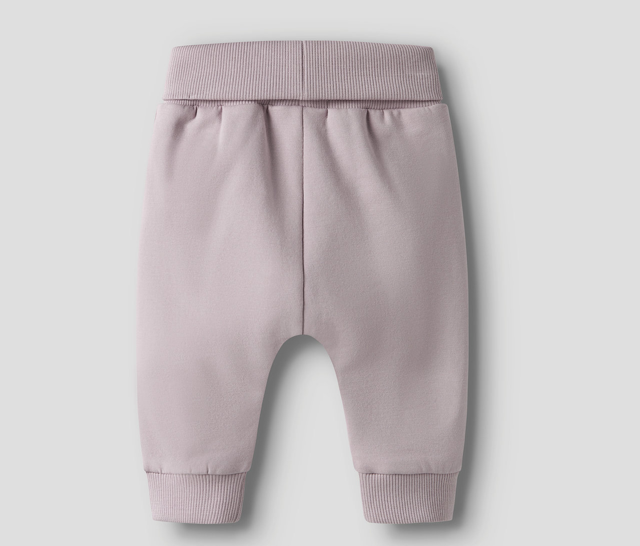 Nahaufnahme einer fliederfarbenen Babyhose mit Rippbündchen an Taille und Knöcheln.