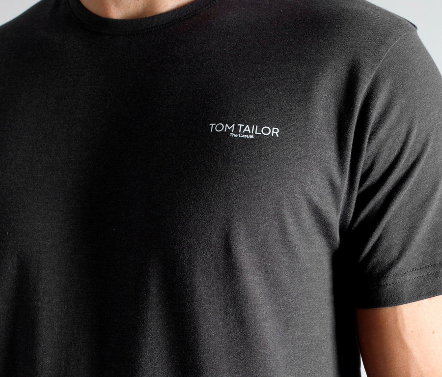 Mann trägt ein graues T-Shirt der Marke Tom Tailor.