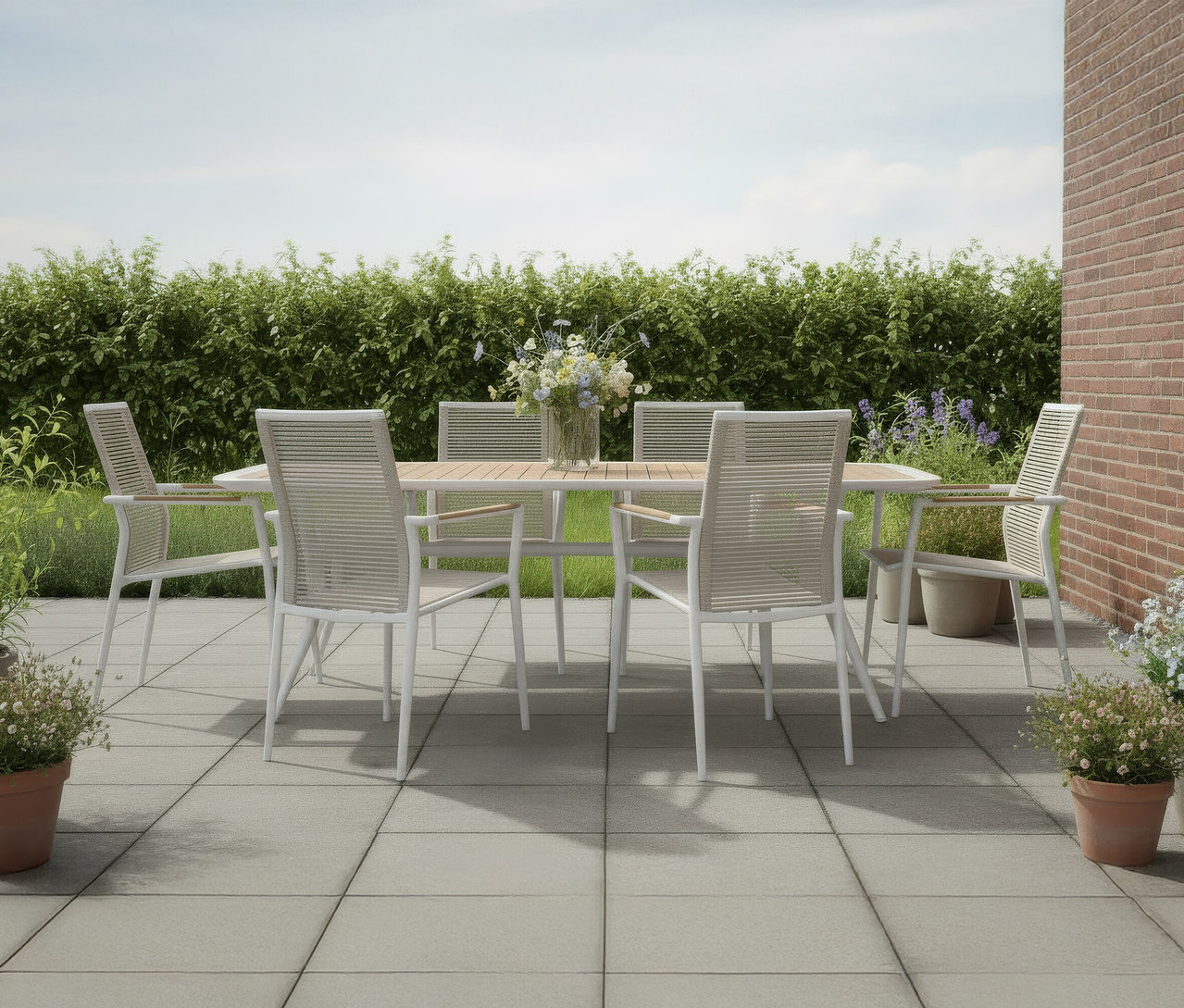 Auf einer Terrasse steht ein DeVries Dining-Set mit einem Tisch (220 x 100cm) und Stapelstühlen (2er-Set).