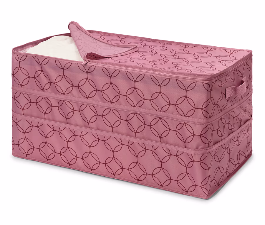 Rosa Stoffbox mit Reißverschluss und geometrischem Muster, teilweise mit weißem Stoff gefüllt.