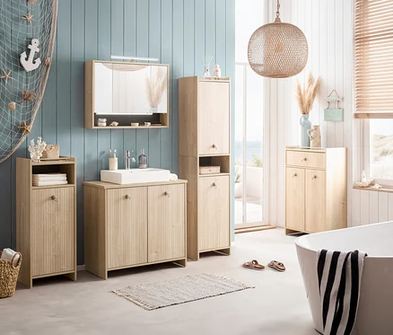 Badezimmer mit Waschtisch, Spiegelschrank, Hochschrank und Badewanne in hellem Holzdekor. Dekorationen wie Seestern und Anker sind angebracht.