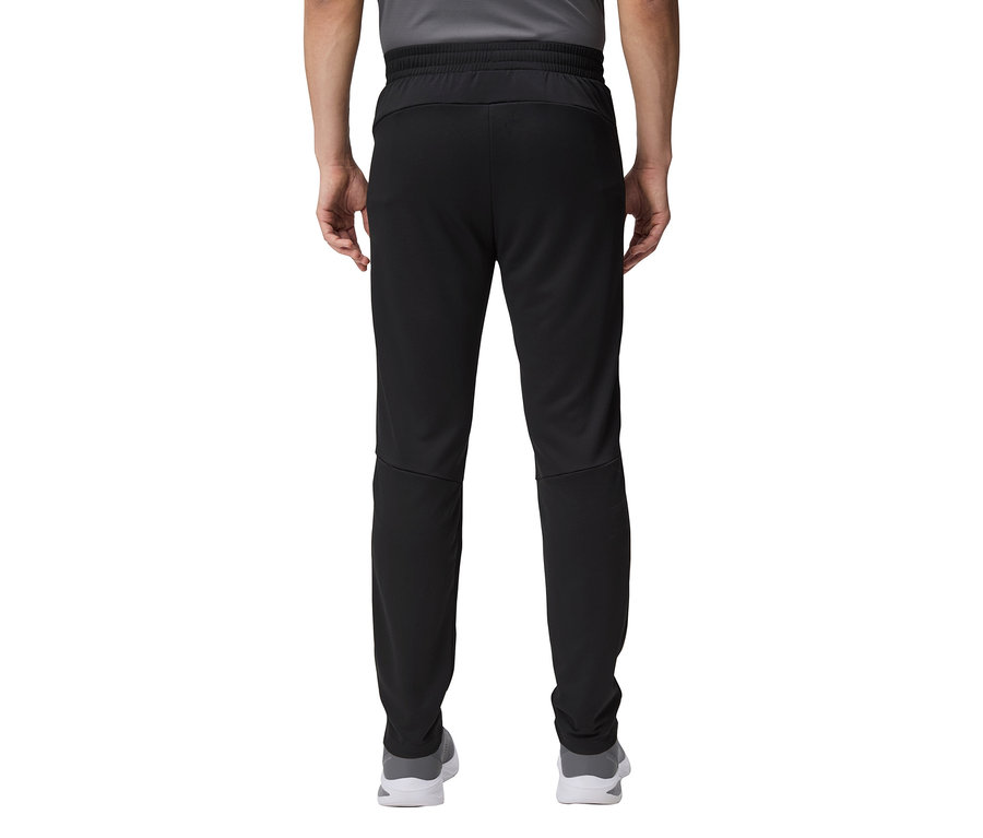 Nahaufnahme der Rückseite einer Person, die eine schwarze Trainingshose und graue Schuhe trägt.