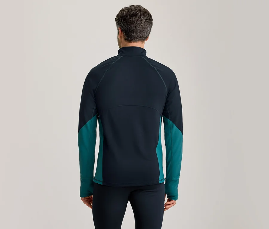 Mann von hinten in einem dunkelblauen Langarmshirt mit türkisen Seitenpartien und dunkelblauer Hose.