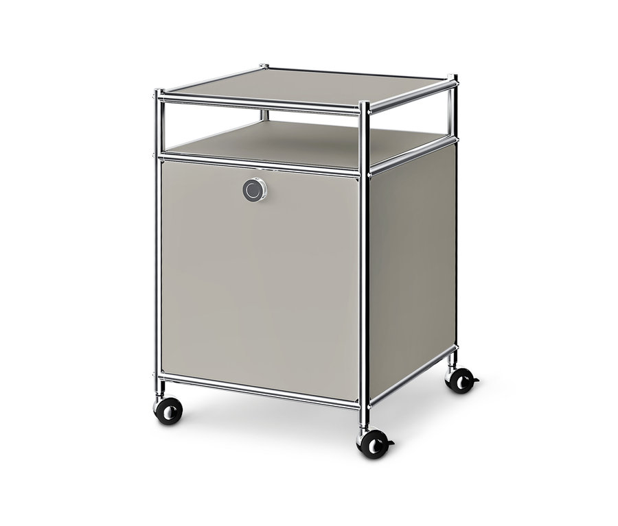 Heller grauer Rollcontainer mit Chromrahmen, offener Ablage oben, geschlossenem Fach mit rundem Griff und schwarzen Rollen.