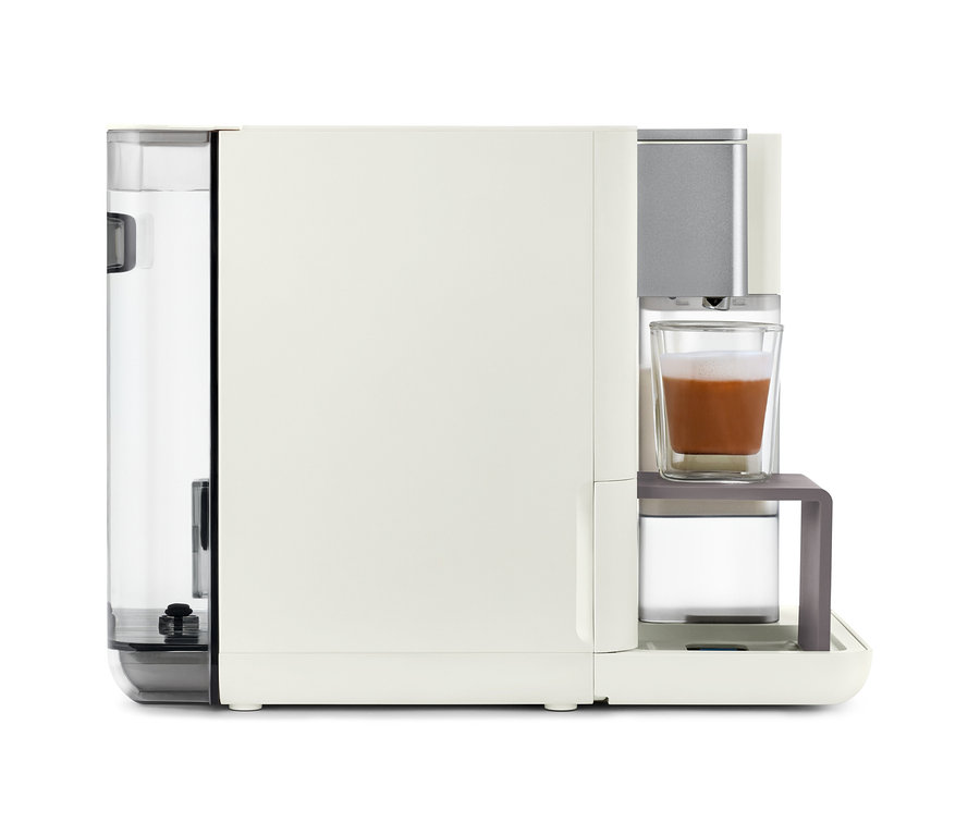 Detailansicht der Qbo MILK MASTER White Cashmere Kaffeemaschine mit einer Tasse Kaffee.