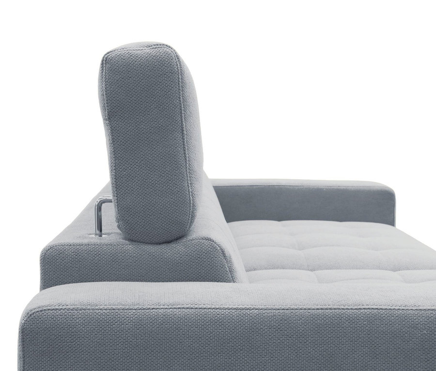 Helles graues Stoffsofa mit verstellbarer Kopfstütze und gesteppter Sitzfläche.