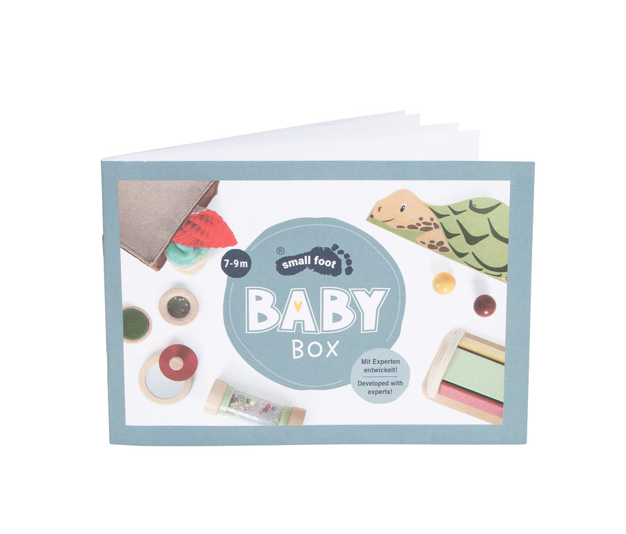 Vorderseite einer hellblauen Baby Box mit der Aufschrift "small foot BABY BOX" und Bildern von Babyspielzeug: ein Stoffbeutel, Holzscheiben, ein Holzring, eine Rassel, eine Schildkrötenzeichnung und Holzbälle.
