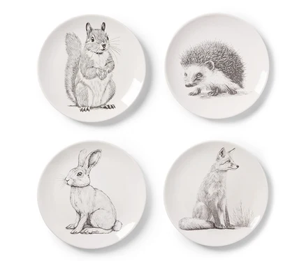 Vier Dessertteller mit Dekor, jeweils mit einem Tiermotiv: Eichhörnchen, Igel, Hase und Fuchs.