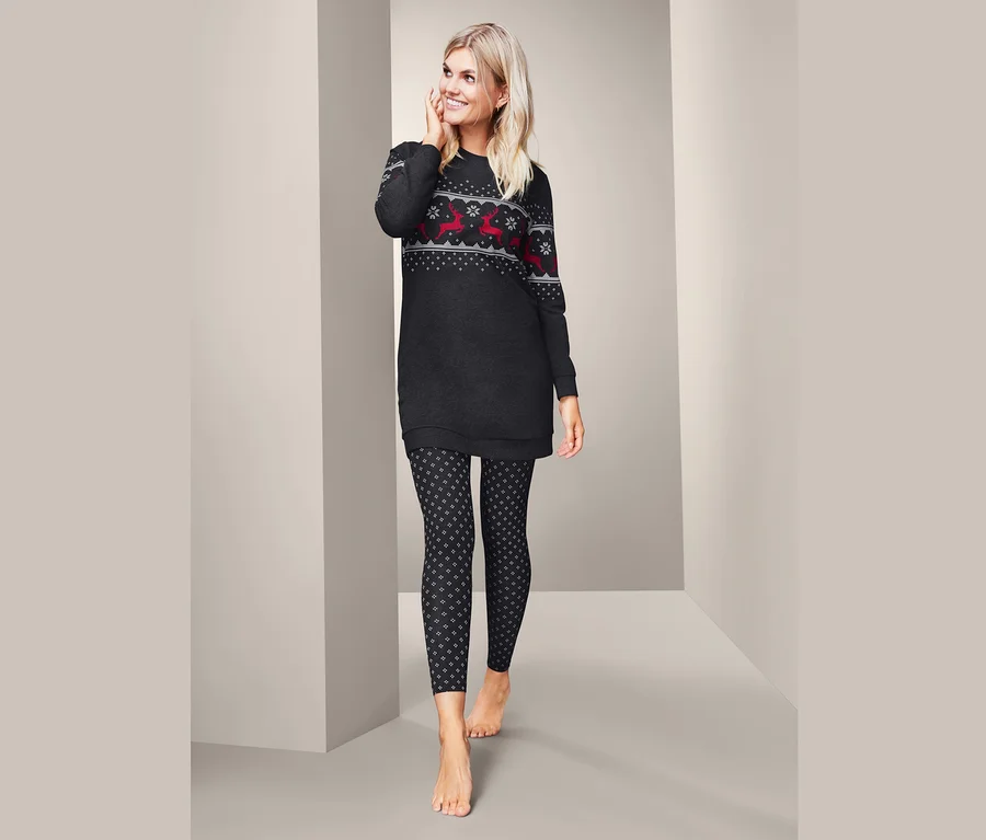 Blonde Frau trägt einen Pyjama mit Weihnachtsmotiv.
