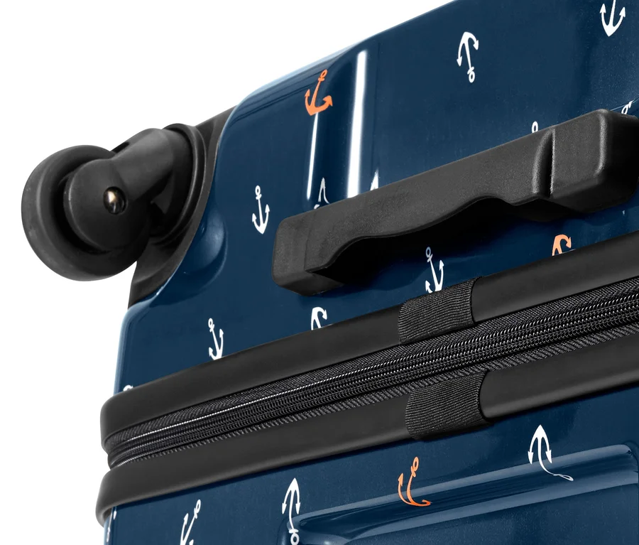 Detailansicht eines kleinen, blauen Hartschalen-Koffers mit weißen und orangefarbenen Ankern.