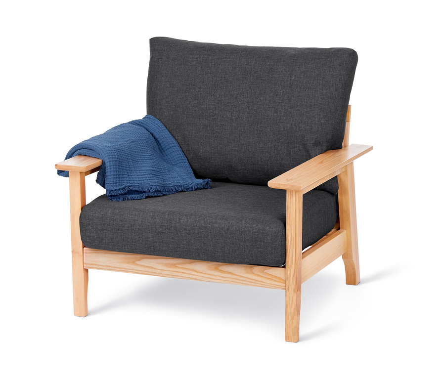 Einzelsessel aus Eschen-Massivholz mit grauem Sitzkissen und blauer Decke.
