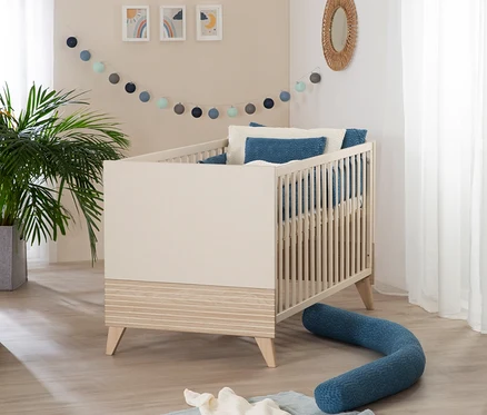 Ein roba Babybett »Sidney«, 70 x 140 cm, in Kaschmir steht in einem Kinderzimmer.