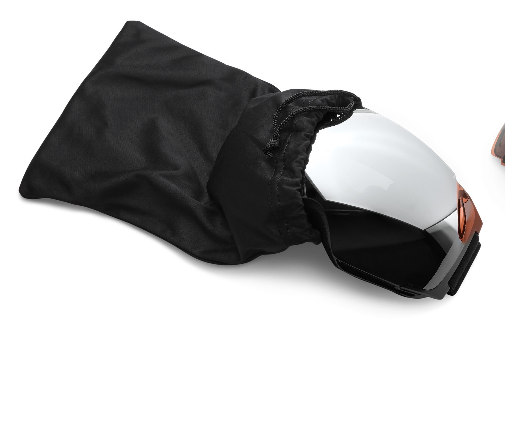 Eine Skibrille mit Wechselgläsern, teilweise aus einem schwarzen Stoffbeutel gezogen, daneben liegt ein auswechselbares Glas.