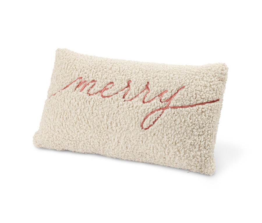 Ein beiges Dekokissen mit dem Schriftzug Merry.