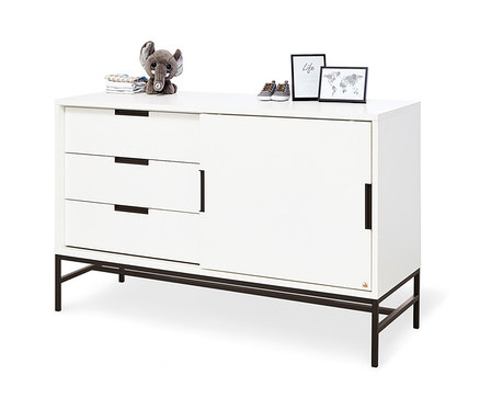 Weisse Kommode mit drei Schubladen und Schiebetüren steht auf schwarzen Metallbeinen. Auf der Kommode liegen ein Plüsch-Elefant, Kleidungsstücke, Babyschuhe und zwei Bilderrahmen. Zu sehen ist das Pinolino Kinderzimmer »Steel«, extrabreit, groß.