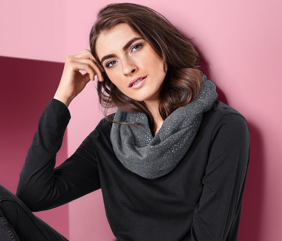 Frau posiert mit einem Fleece-Loopschal.