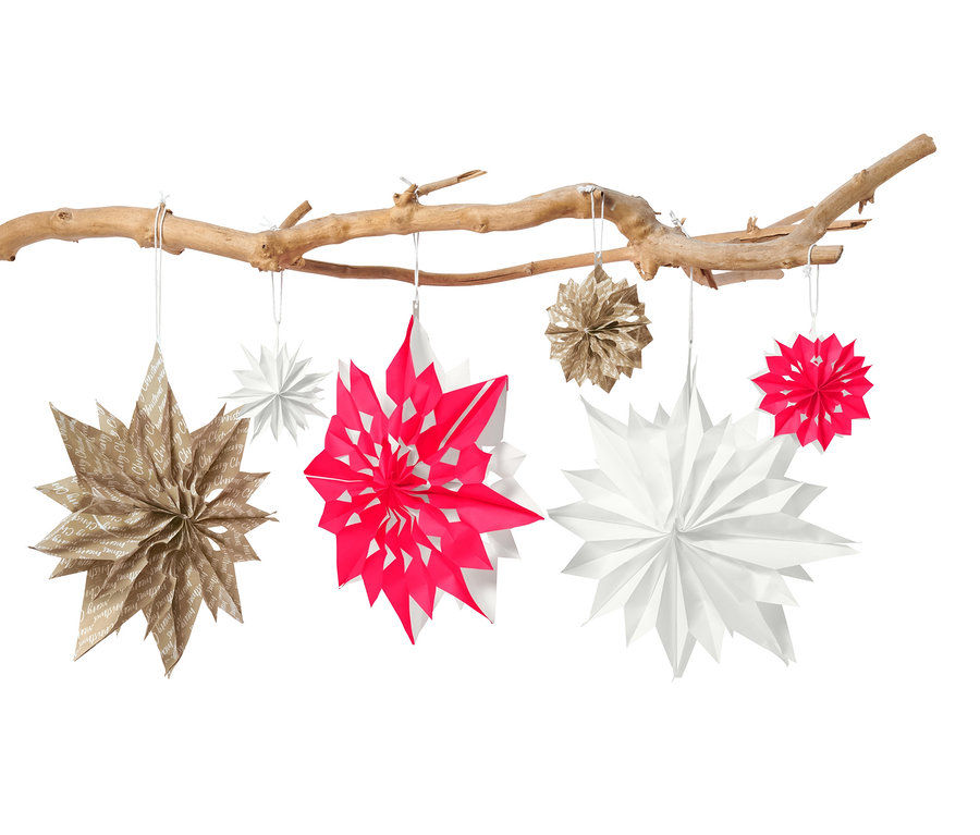 An einem Ast hängen Papiersterne aus dem Papiertüten-Sterne-Bastel-Set.