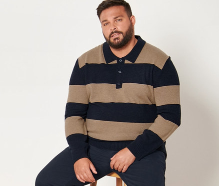 Mann sitzt auf einem Hocker, trägt eine dunkelblaue Chino und einen gestreiften Pullover mit Cashmere-Anteil.