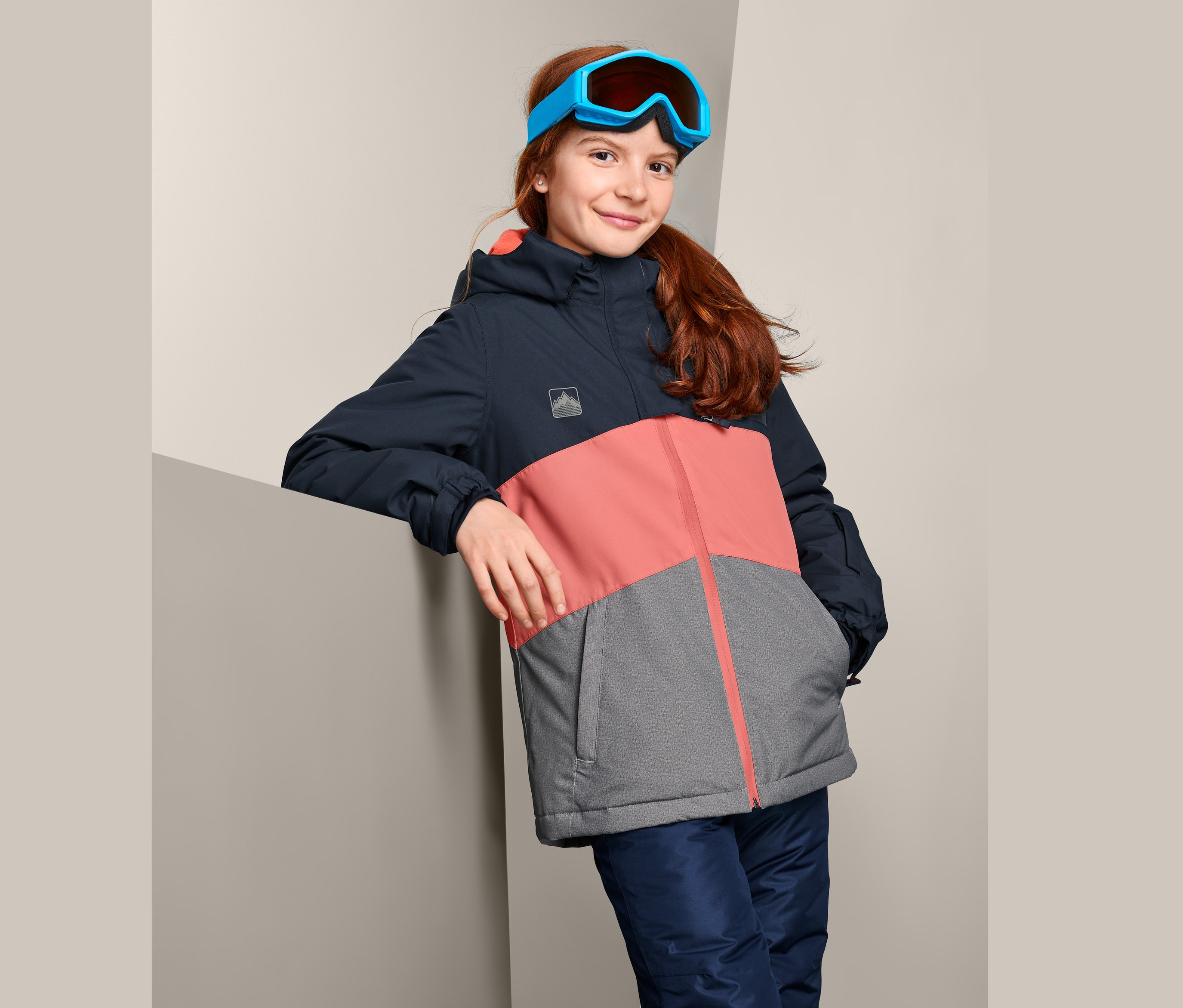 Mädchen mit Skibrille und Thermo-Snowboardjacke.
